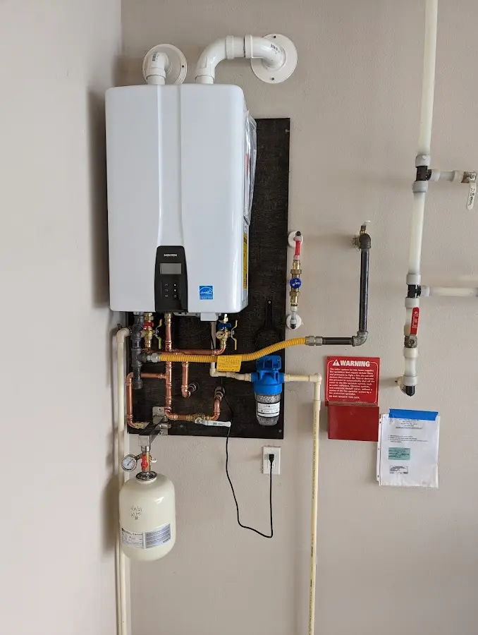 Professional plumber installing copper piping in a North East home